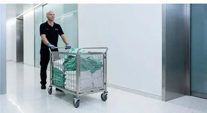 Sitex-Mitarbeiter transportiert Textilien im Rollwagen